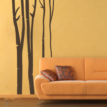 Primer izgleda čokoladno rjave samolepilne stenske nalepke Breza na oranžni steni v dnevni sobi.