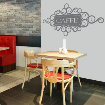 Primer izgleda grafitno sive stenske nalepke Caffe na beli steni v kavarni. Nalepka je napis, ki se glasi: Caffe.