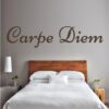 Nadomestno besedilo + besedilo v sliki Primer izgleda čokoladno rjave stenske nalepke Carpe Diem na svetlo sivi steni nad posteljo v spalnici. Nalepka je napis, ki se glasi: Carpe Diem.