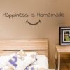 Primer izgleda čokoladno rjave samolepilne stenske nalepke Happiness is Homemade na bež steni v spalnici. Nalepka je napis, ki se glasi: Happiness is Homemade.