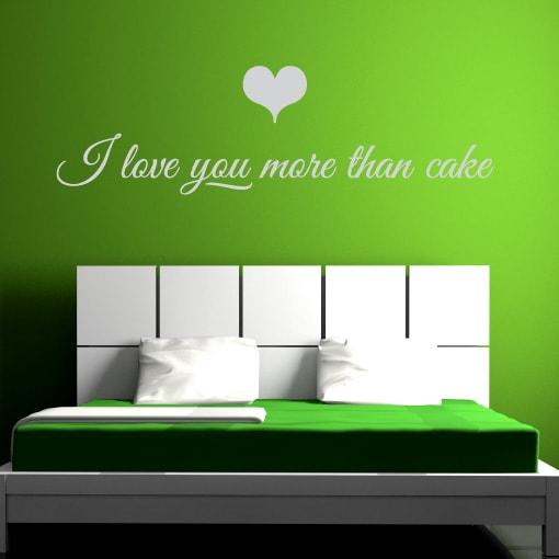 Primer izgleda bele samolepilne stenske nalepke I love you more then cake na zeleni steni v spalnici. Nalepka je napis, ki se glasi: I love you more then cake.
