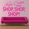 Primer izgleda roza samolepilne stenske nalepke Keep calm and shop shop shop na roza steni nad zofo. Nalepka je napis, ki se glasi: Keep calm and shop shop shop!