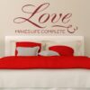 Primer izgleda temno rdeče samolepilne stenske nalepke Love na bež steni v spalnici. Nalepka je napis, ki se glasi: Love makes life complete.