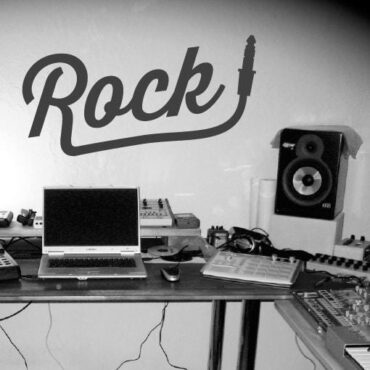 Primer izgleda črne samolepilne stenske nalepke Rock plug na sivi steni v studiu.