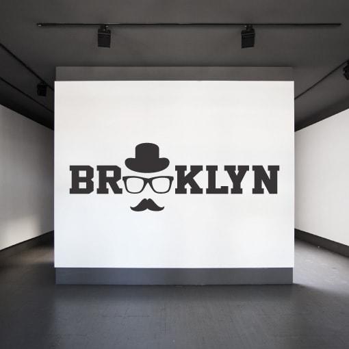 Primer izgleda črne samolepilne stenske nalepke Brooklyn Sir na beli steni v studiu. Na nalepki piše: Brooklyn