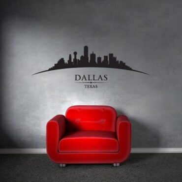 Primer izgleda črne samolepilne stenske nalepke Dallas ukrivljen na sivi steni v dnevni sobi.