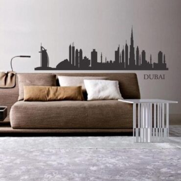 Primer izgleda grafitno sive samolepilne stenske nalepke Dubai 1 na bež steni v dnevni sobi.