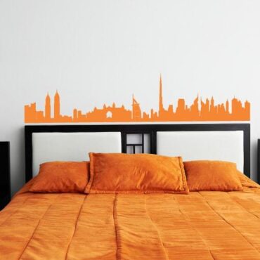 Primer izgleda oranžne samolepilne stenske nalepke Dubai orange na beli steni v spalnici.