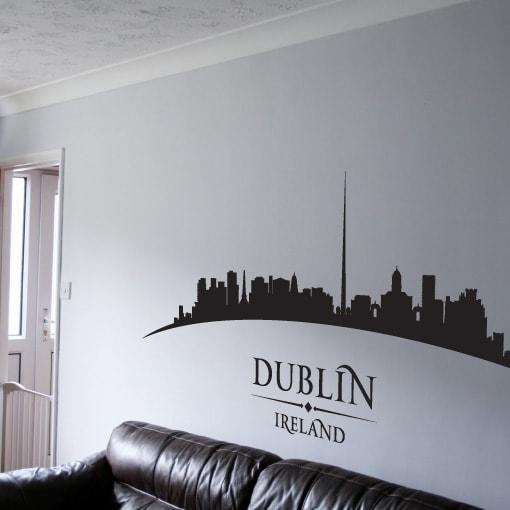 Primer izgleda črne samolepilne stenske nalepke Dublin ukrivljen na beli steni v dnevni sobi.