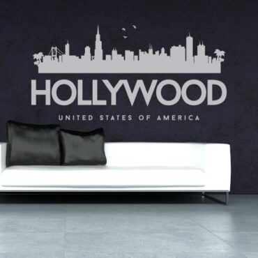 Primer izgleda sive samolepilne stenske nalepke Hollywood na sivi steni nad zofo v dnevni sobi.