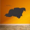 Primer izgleda črne samolepilne stenske nalepke Koroška na oranžni steni v dnevni sobi.