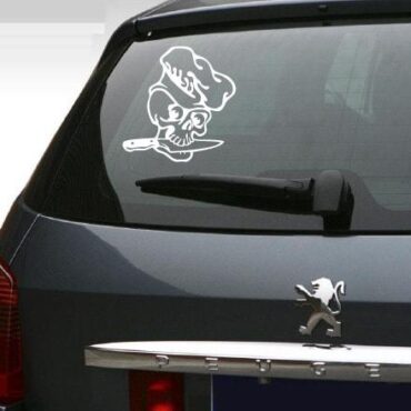 Primer izgleda bele samolepilne avto nalepke Kuhar okostnjak na zadnjem steklu avta črne barve.