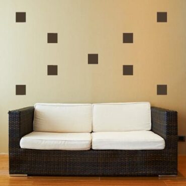 Primer izgleda čokoladno rjave samolepilne stenske nalepke Kvadrati na bež steni v dnevni sobi.