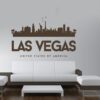 Primer izgleda čokoladno rjave samolepilne stenske nalepke Las Vegas Luna na beli steni nad zofo v dnevni sobi. Na nalepki piše: Las Vegas, United Sates of America