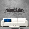 Primer izgleda črne samolepilne stenske nalepke Las Vegas zaviti na sivi steni nad sedežno v dnevni sobi. Na nalepki piše: Las Vegas, United Sates
