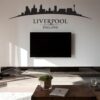 Primer izgleda črne samolepilne stenske nalepke Liverpool ukrivljen na beli steni v dnevni sobi.