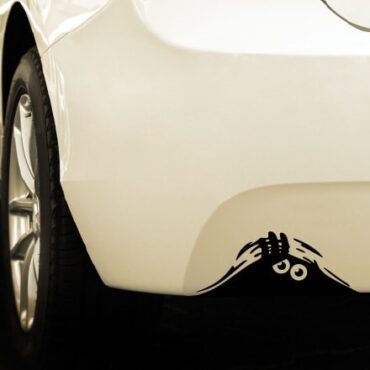 Primer izgleda črne samolepilne avto nalepke Mala pošast na avtu bele barve.