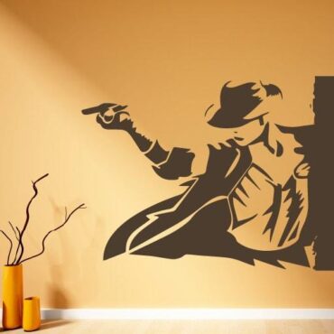 Primer izgleda čokoladno rjave samolepilne stenske nalepke Michael Jackson 2 na oranžni steni v dnevni sobi.