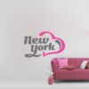 Primer izgleda dvobarvne samolepilne stenske nalepke New York Heart na beli steni v dnevni sobi. Na nalepki piše: New York