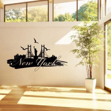 Primer izgleda črne samolepilne stenske nalepke New York packa na beli steni v dnevni sobi. Na nalepki piše: New York