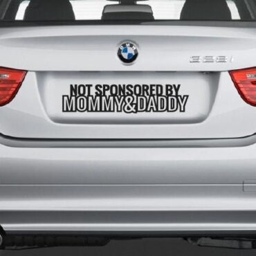 Primer izgleda črne samolepilne avto nalepke Not sponsored na avtu srebrne barve. Nalepka je napis, ki se glasi: Not sponsored by Mommy & Daddy.