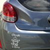 Primer izgleda bele samolepilne avto nalepke Otrok v avtu 3 na avtu sive barve. Nalepka je napis, ki se glasi: Otrok v avtu - Ime otroka