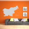 Primer izgleda sive samolepilne stenske nalepke Slovenija Kura na oranžni steni v dnevni sobi.