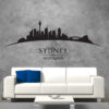 Primer izgleda črne samolepilne stenske nalepke Sydney ukrivljen na sivi steni v dnevni sobi.