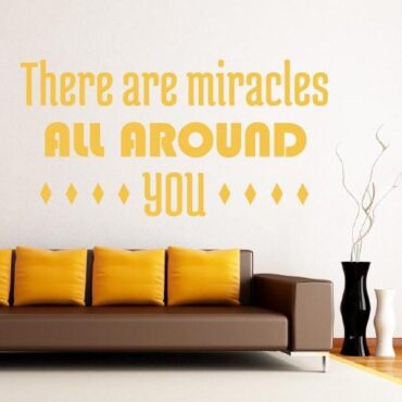 Primer izgleda zlate samolepilne stenske nalepke There are miracles na beli steni v dnevni sobi. Nalepka je napis, ki se glasi: There are miracles all around you.