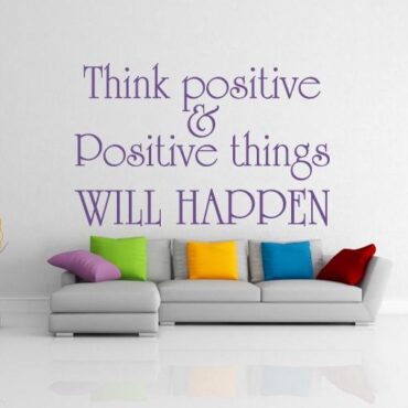 Primer izgleda vijolične samolepilne stenske nalepke Think positive na beli steni v dnevni sobi. Nalepka je napis, ki se glasi: Think positive & positive things WILL HAPPEN.