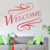 Primer izgleda rdeči samolepilne stenske nalepke Welcome na beli steni v dnevni sobi. Nalepka je napis, ki se glasi: Welcome.