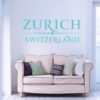 Primer izgleda turkizno zelene samolepilne stenske nalepke Zurich Switzerland na modri steni v dnevni sobi.